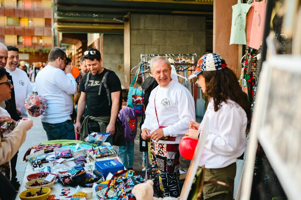 Visitantes y voluntarios compartiendo un momento durante un Mercadillo Solidario organizado por la Fundación Aragón Solidario por la Cultura.