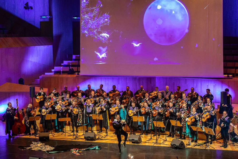 La Tuna de Ingenieros de Zaragoza actúa durante la gala solidaria Voces que Importan con una proyección audiovisual en el escenario.